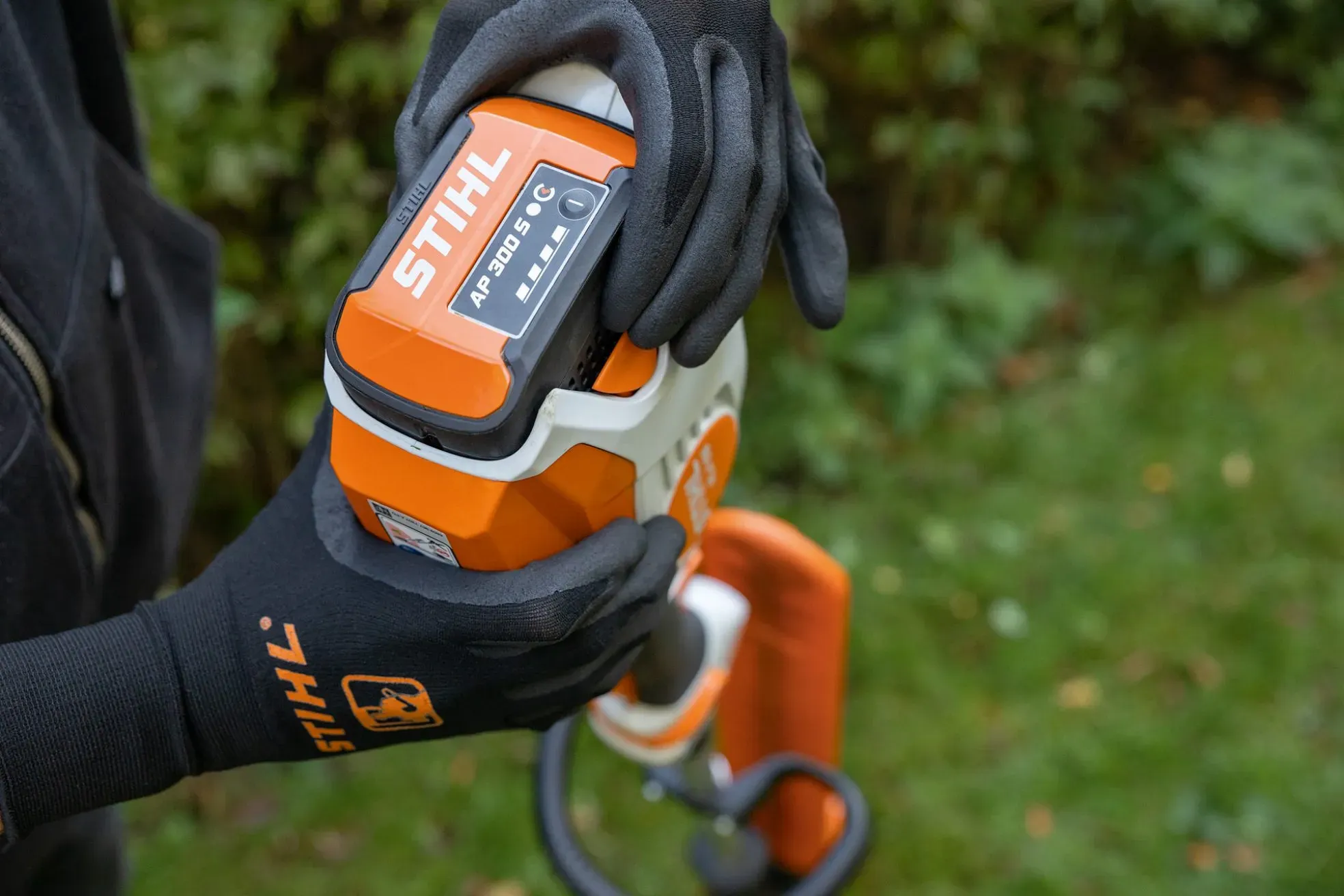 A modern STIHL battery-powered tool charging in a workshop