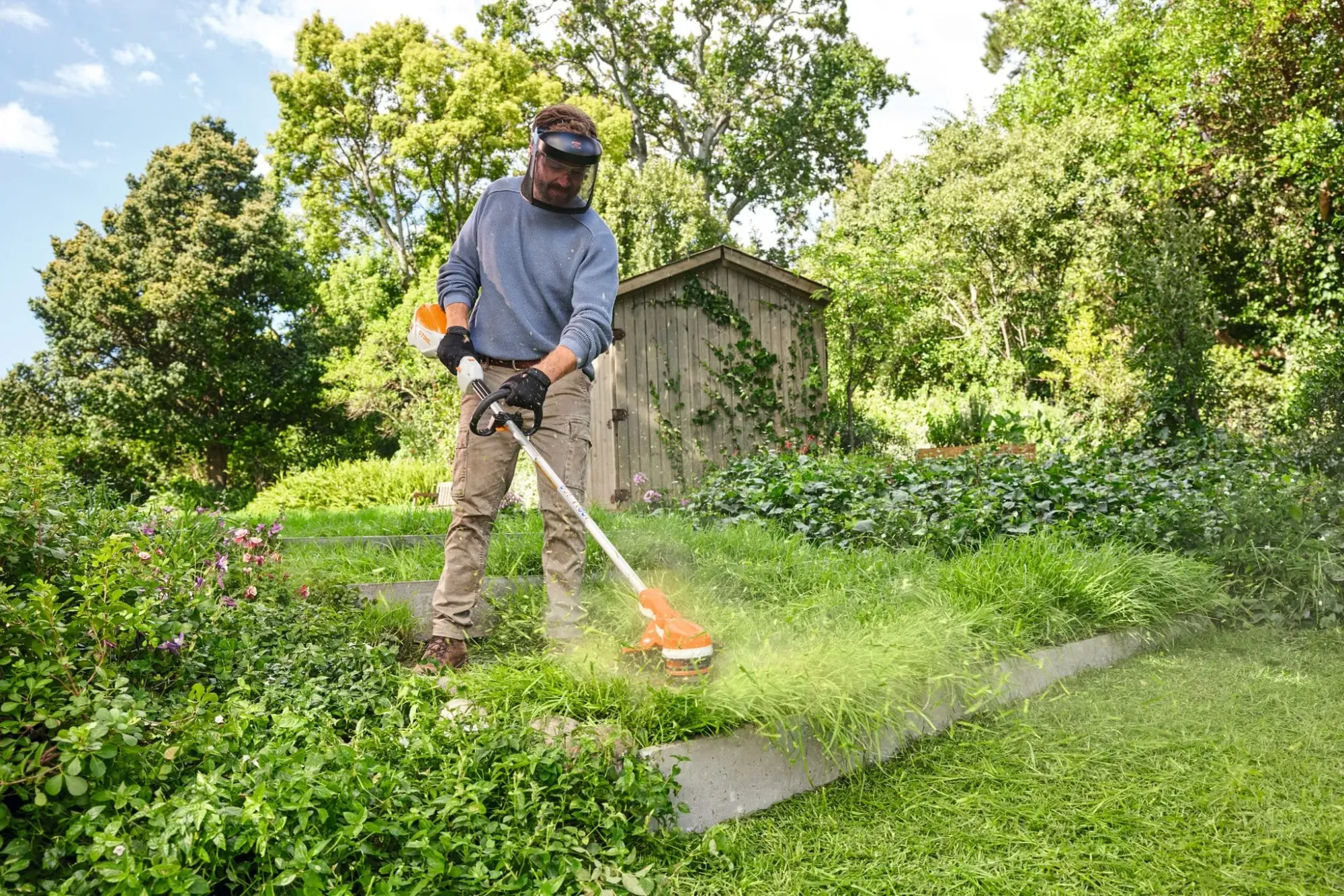 Kiwi homeowner using STIHL outdoor power equipment in a backyard